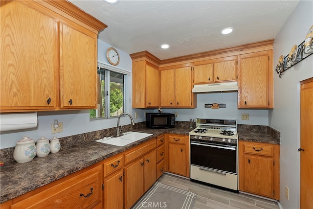 kitchen featuring sink, white gas range oven, dark stone countertops, and light tile flooring