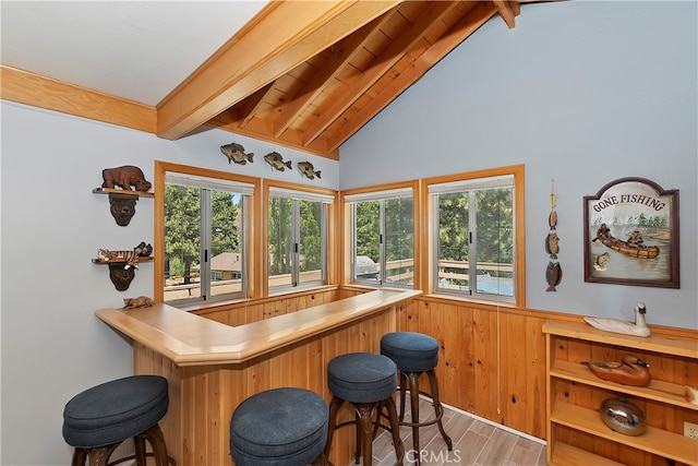 bar featuring hardwood / wood-style floors and lofted ceiling with beams