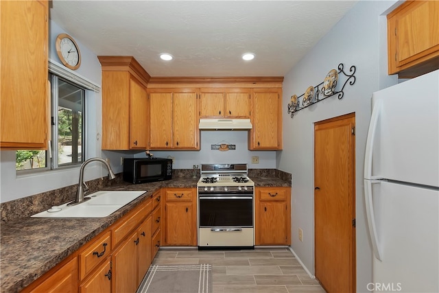 kitchen featuring white appliances, sink, and light tile floors