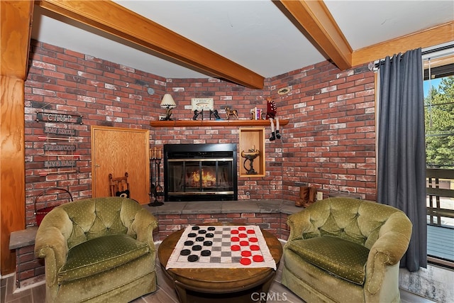 living room with brick wall, beamed ceiling, and a fireplace