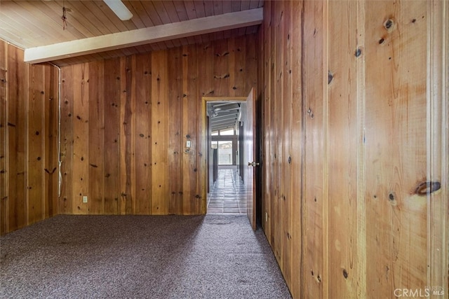 hallway featuring vaulted ceiling with beams, carpet flooring, wood ceiling, and wooden walls