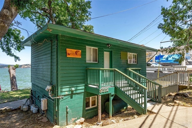 view of front facade with a deck with water view