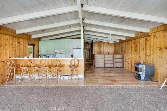 kitchen with kitchen peninsula, a breakfast bar, lofted ceiling with beams, white refrigerator, and ceiling fan