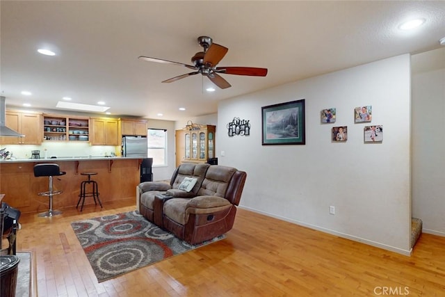 living room featuring light wood-type flooring and ceiling fan