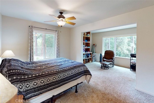 bedroom featuring carpet, ceiling fan, and multiple windows