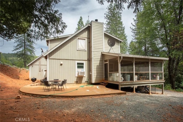 rear view of property featuring cooling unit, a patio area, and a sunroom