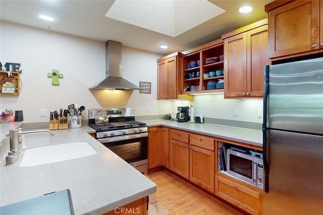 kitchen with kitchen peninsula, light wood-type flooring, wall chimney exhaust hood, stainless steel appliances, and sink