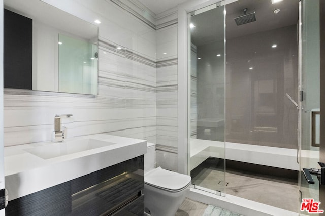 bathroom featuring vanity, a shower with shower door, and toilet