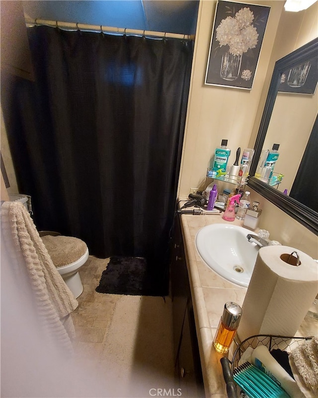 bathroom featuring tile flooring, large vanity, and toilet