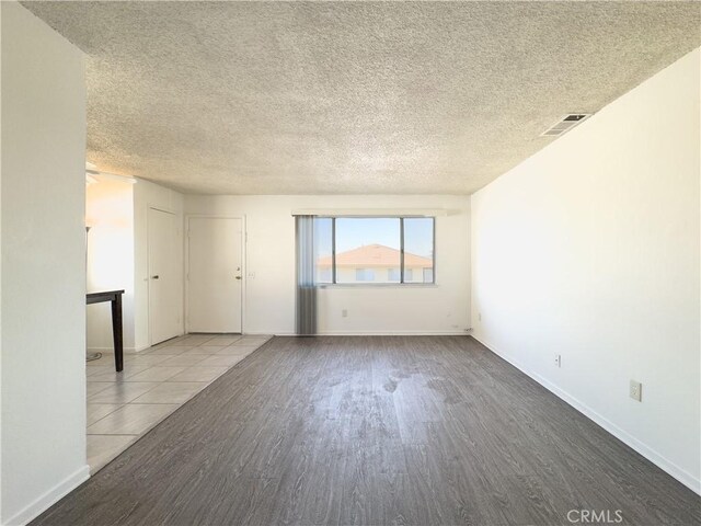 spare room with hardwood / wood-style flooring and a textured ceiling