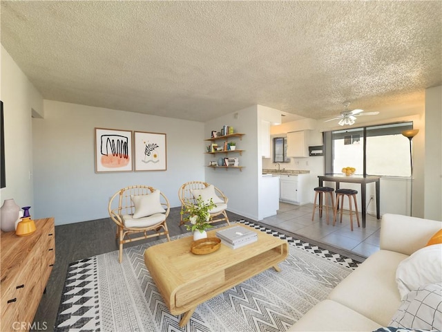 living room with light tile patterned floors, a textured ceiling, and ceiling fan