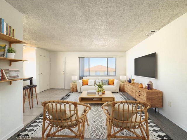 living room featuring a textured ceiling and light tile patterned floors