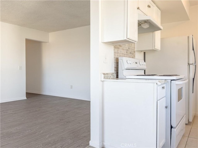 kitchen with white electric range oven, light hardwood / wood-style floors, a textured ceiling, white cabinets, and decorative backsplash