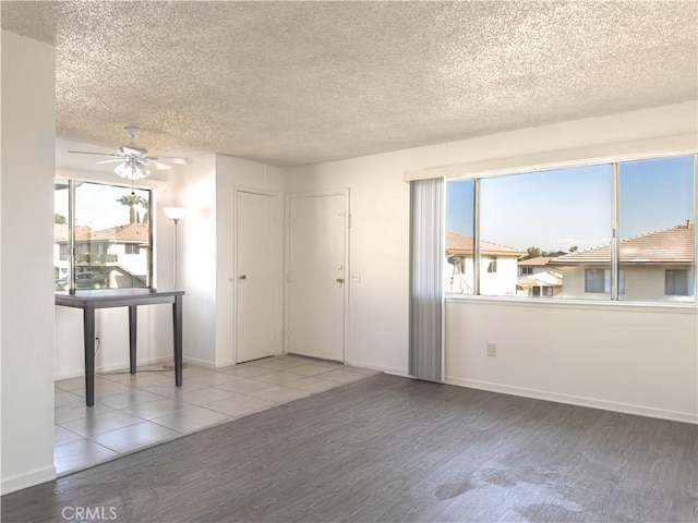 empty room featuring ceiling fan, hardwood / wood-style floors, and a textured ceiling