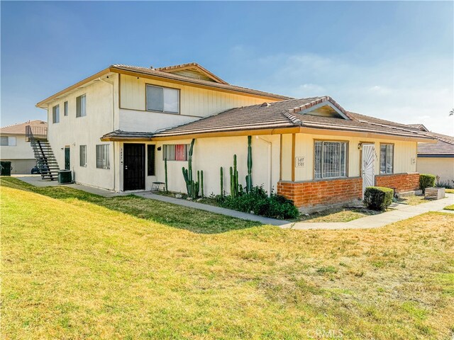 rear view of house with a yard and central AC