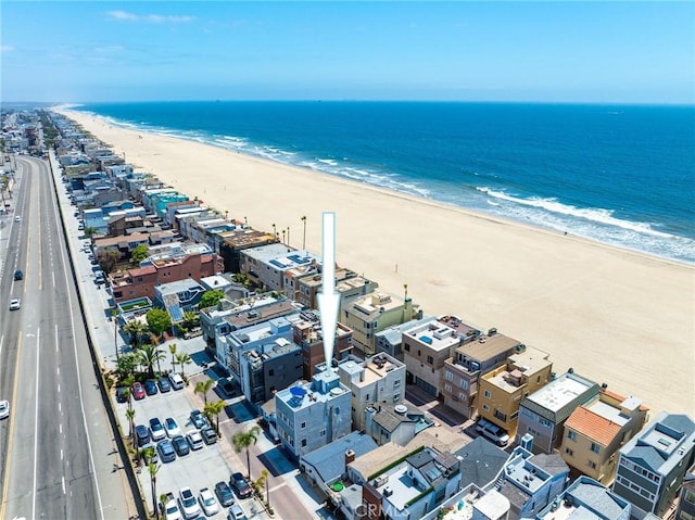 birds eye view of property with a water view and a beach view