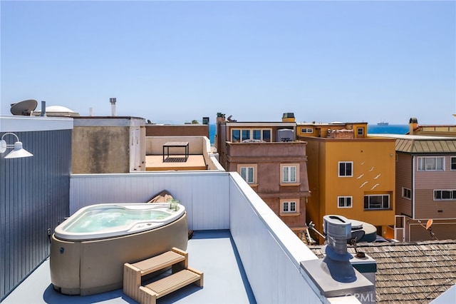 view of patio featuring a balcony and a hot tub