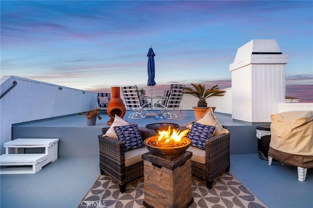 patio terrace at dusk featuring a fire pit