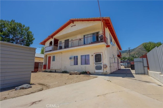 back of property featuring a mountain view and a balcony