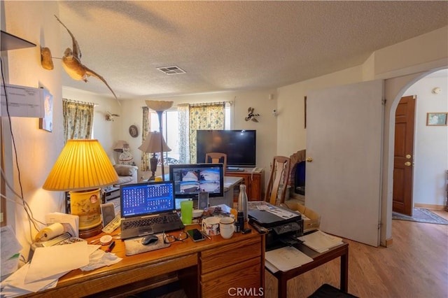 office area with light hardwood / wood-style flooring and a textured ceiling