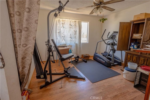 workout area with ceiling fan, a textured ceiling, and light hardwood / wood-style flooring