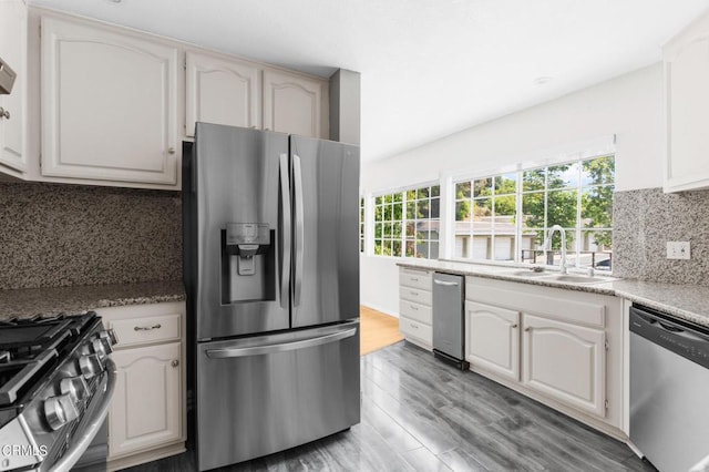 kitchen featuring white cabinets, appliances with stainless steel finishes, light hardwood / wood-style floors, and sink