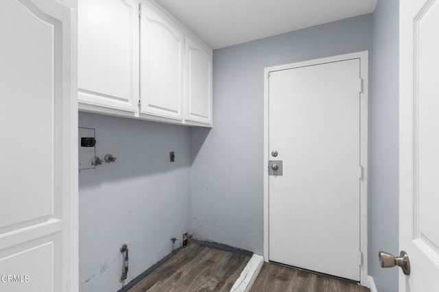 washroom with gas dryer hookup, cabinets, dark hardwood / wood-style floors, and hookup for an electric dryer