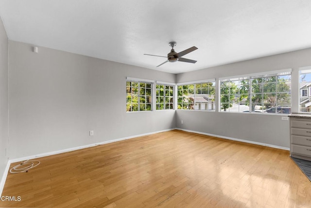 spare room with ceiling fan, plenty of natural light, and light wood-type flooring