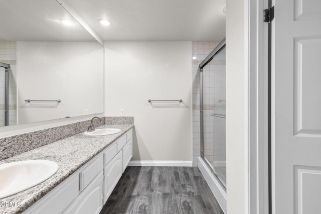 bathroom featuring vanity, an enclosed shower, and wood-type flooring