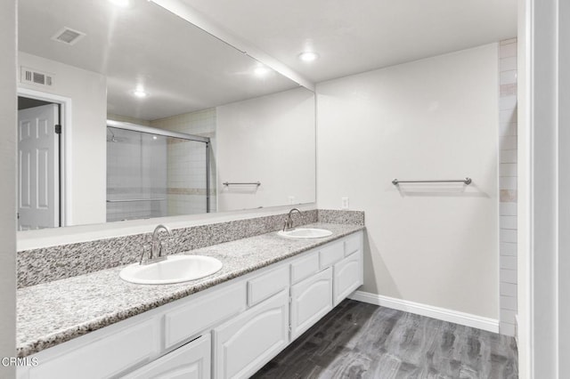 bathroom featuring vanity, wood-type flooring, and an enclosed shower