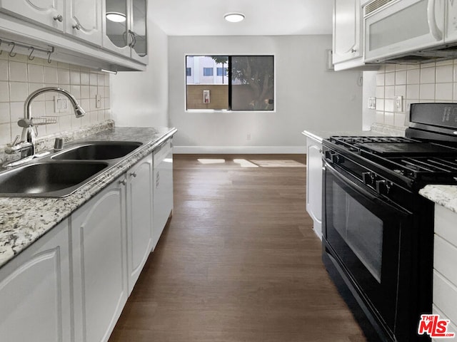 kitchen with tasteful backsplash, sink, white cabinets, and white appliances