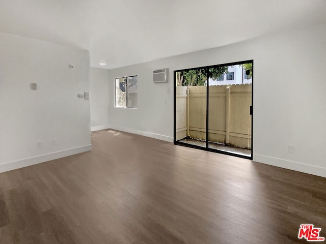 spare room featuring hardwood / wood-style flooring, a wealth of natural light, and a wall mounted AC