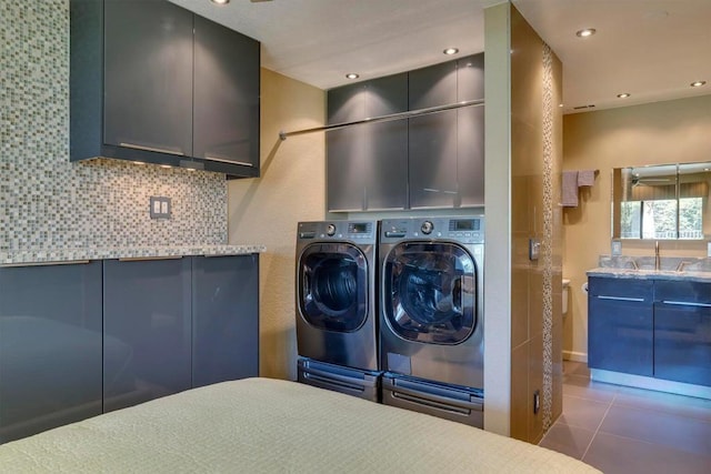 laundry room featuring tile patterned floors, sink, cabinets, and independent washer and dryer