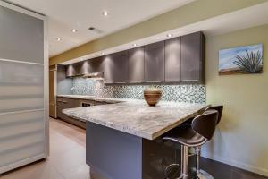 kitchen with a kitchen breakfast bar, kitchen peninsula, light stone counters, and tasteful backsplash