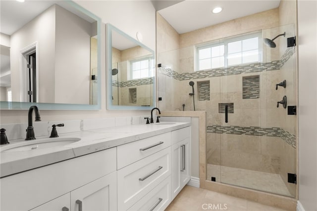 bathroom with a shower with door, vanity, and tile patterned flooring