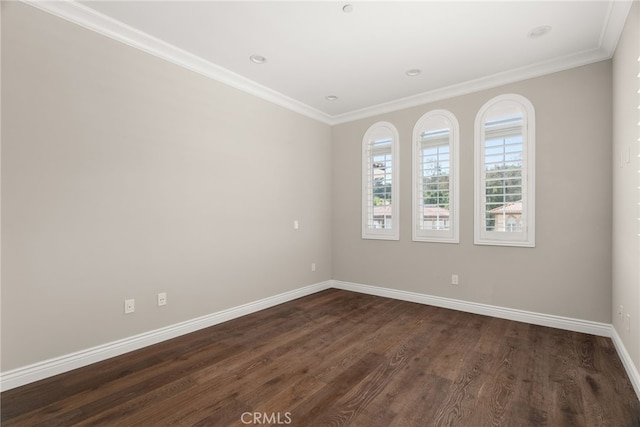 spare room featuring dark hardwood / wood-style flooring and crown molding