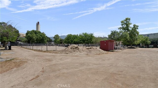 view of yard with a rural view, a mountain view, and an outdoor structure