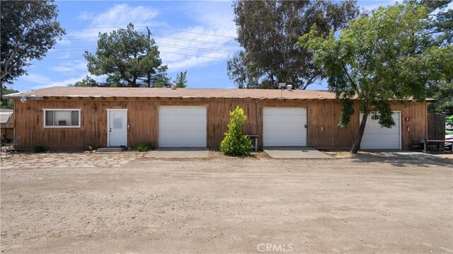 view of front of house with a garage and an outbuilding