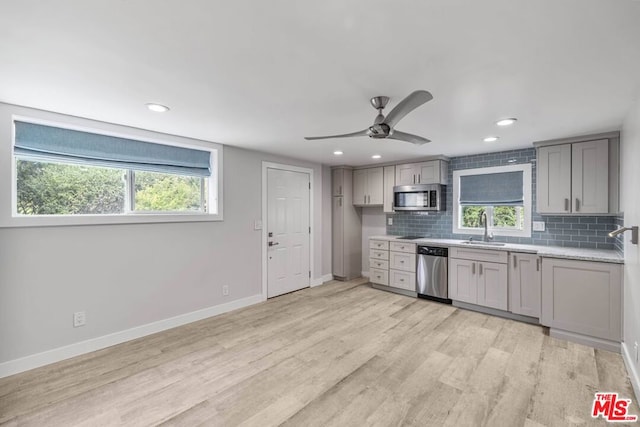 kitchen with stainless steel appliances, light hardwood / wood-style flooring, backsplash, and sink