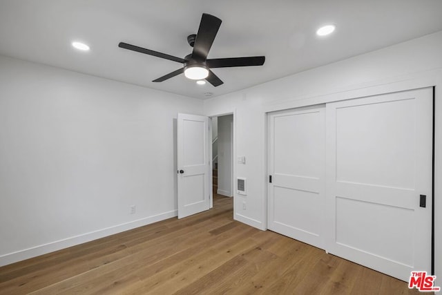 unfurnished bedroom with ceiling fan, a closet, and light hardwood / wood-style floors