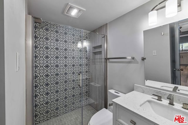 bathroom featuring an enclosed shower, vanity, and toilet