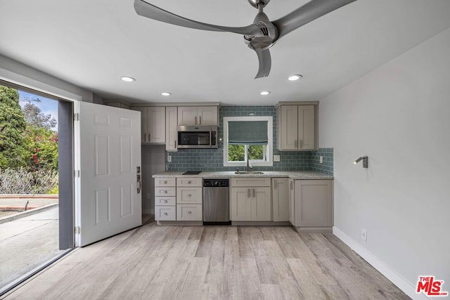 kitchen featuring ceiling fan, light hardwood / wood-style floors, tasteful backsplash, and appliances with stainless steel finishes