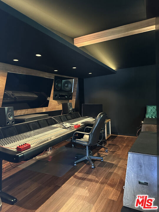 home office with beam ceiling and hardwood / wood-style flooring