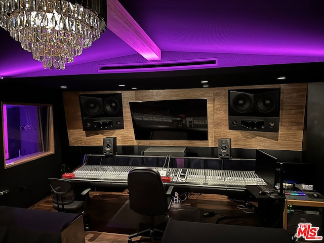 home office with beam ceiling and an inviting chandelier