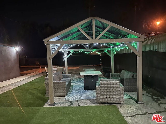 patio at twilight featuring outdoor lounge area and a gazebo