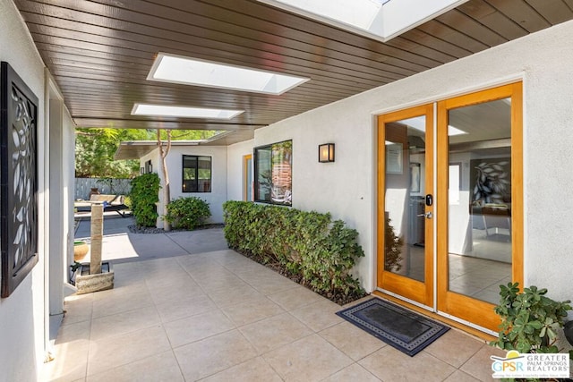 view of exterior entry with french doors and a patio