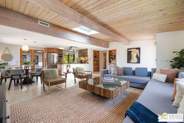 tiled living room with beam ceiling, a skylight, and wooden ceiling