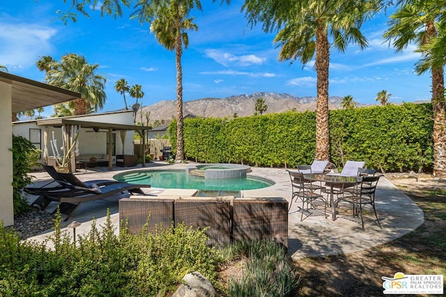 view of pool with an in ground hot tub, a mountain view, a patio, and ceiling fan