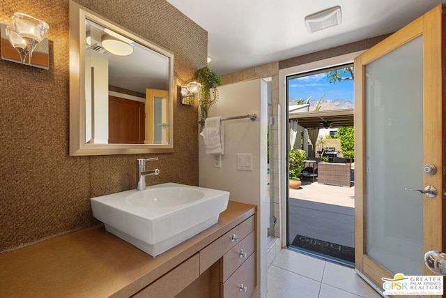 bathroom with tile patterned flooring, vanity, and a shower