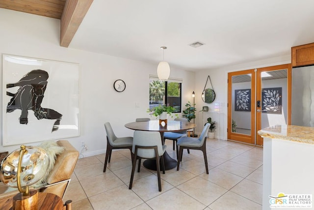 dining area with french doors, light tile patterned floors, and beamed ceiling